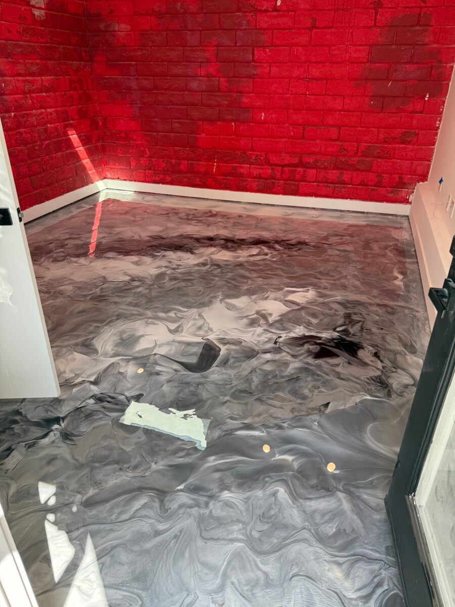 Red and gray metallic epoxy garage floor coating with decorative accent finish